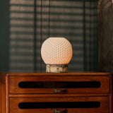 Mare cordless table lamp on a wooden nightstand in front of striped window blinds