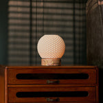 Mare rechargeable table lamp with pink marble base set against striped blinds and a bedside chest