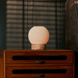 Mare rechargeable table lamp with pink marble base set against striped blinds and a bedside chest