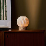 Mare rechargeable table lamp with textured porcelain shade and pink marble base on a wood sideboard