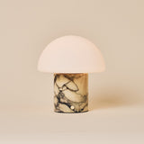 Cordless table lamp showing the yellow marble base and half-dome glass shade