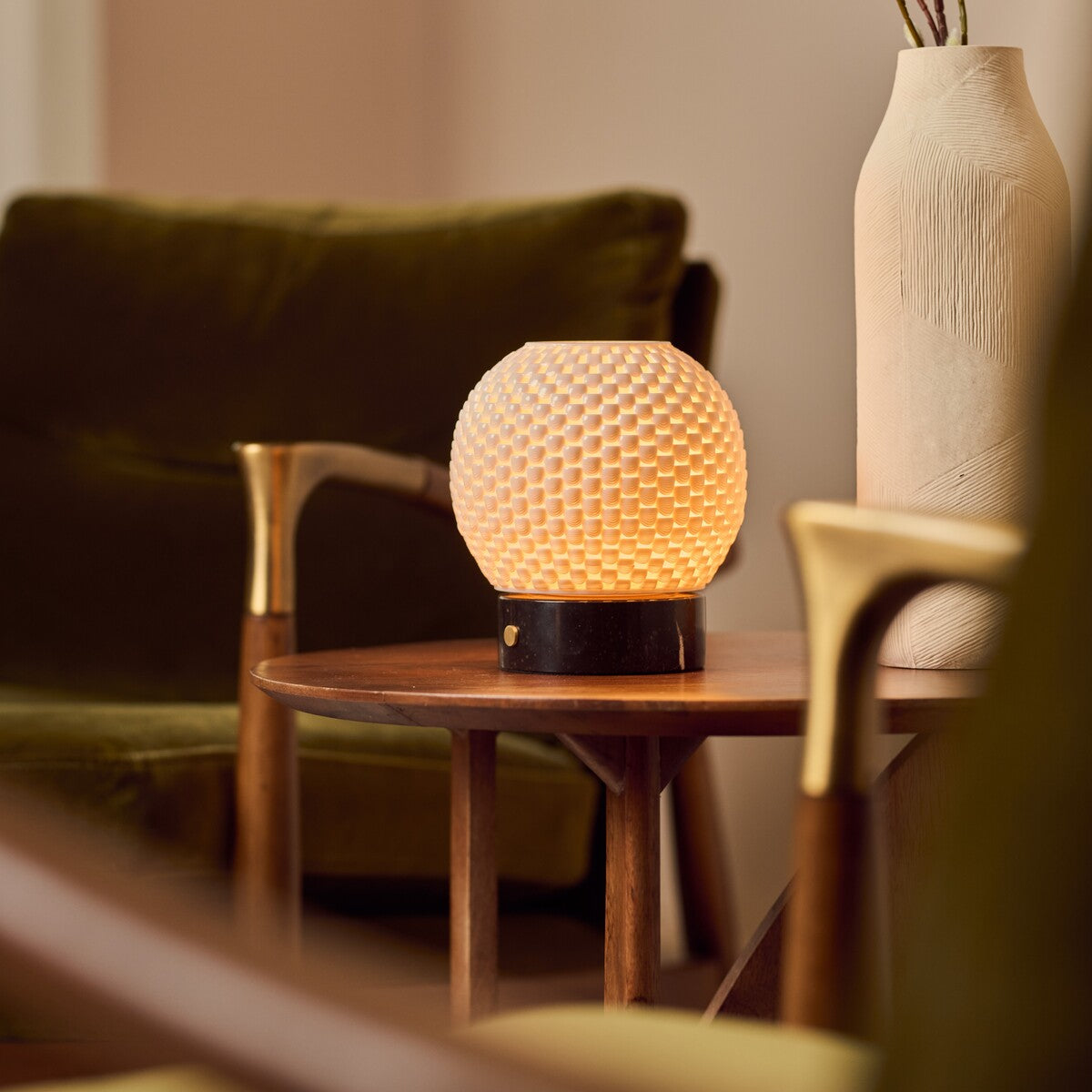 Oplaadbare tafellamp Mare zwart marmer op ronde houten bijzettafel tussen groene fauteuils