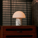 Oplaadbare tafellamp Maris in wit Arabescato marmer op dressoir bij lamellen-lichtinval
