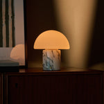 Oplaadbare tafellamp Maris in wit Arabescato marmer op dressoir bij ingelijste kunst en warme wand