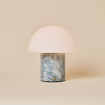Tafellamp oplaadbaar Maris in blauwgrijs calciet marmer, studio-opname op beige achtergrond