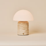 Oplaadbare tafellamp Maris Large met beige classic travertin voet tegen neutrale achtergrond