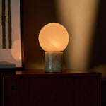 Oplaadbare tafellamp Metsu Honey Onyx marmer naast ingelijste kunst op dressoir