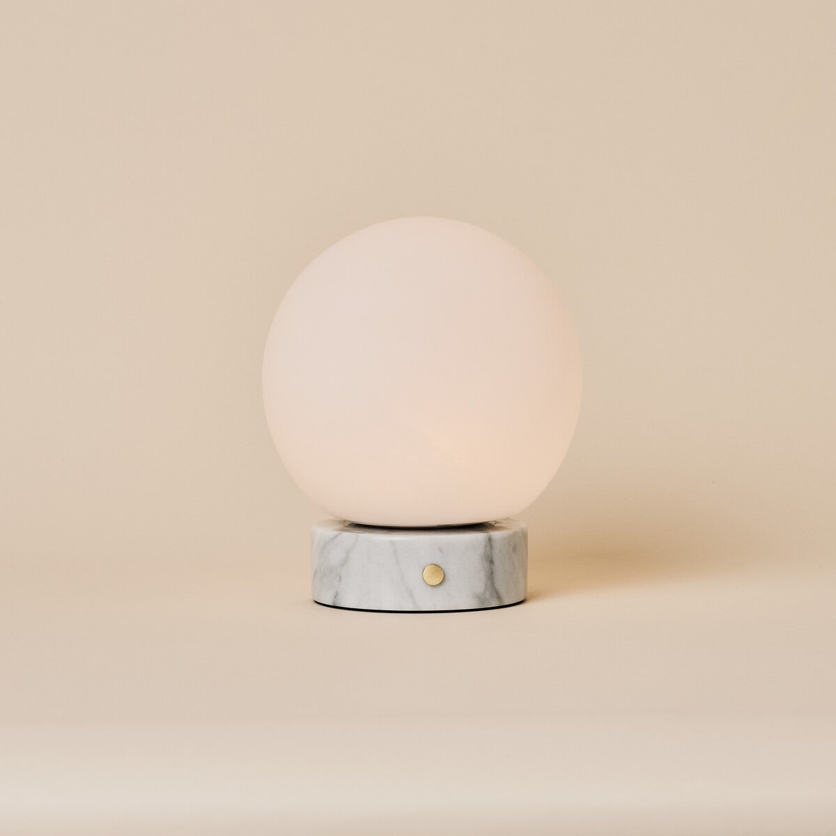 Oplaadbare tafellamp Metsu witte marmeren voet en ronde opaline bolkap op neutrale achtergrond