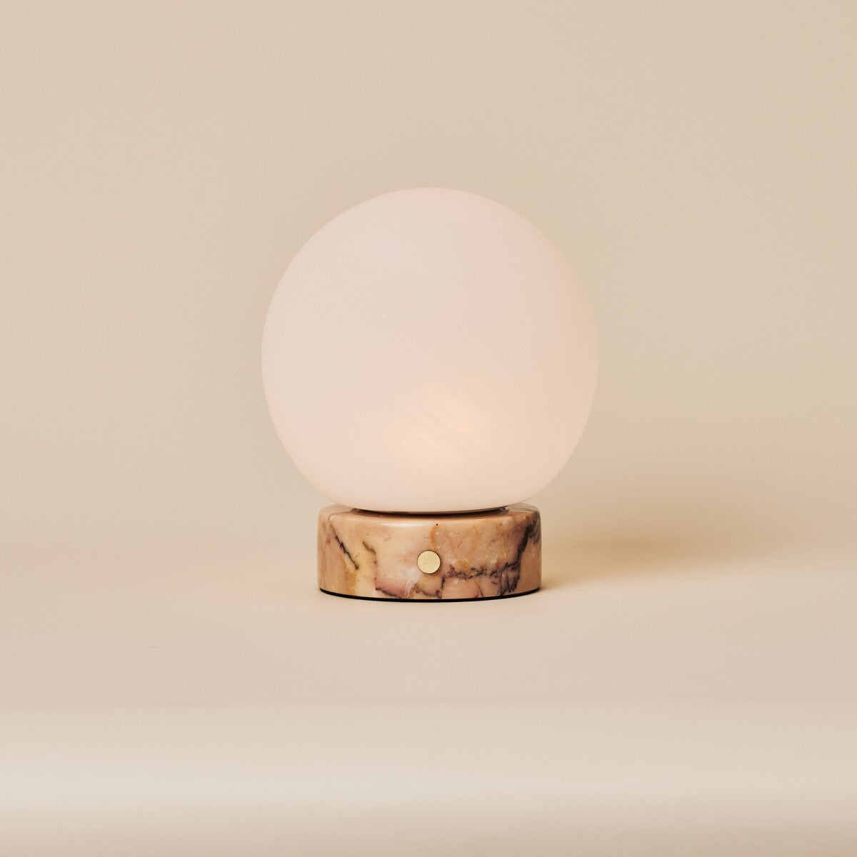 Rechargeable table lamp Metsu Small in Calacatta Vionaro pink marble on a neutral background