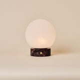 Tafellamp oplaadbaar Metsu Small Rosso Levanto marmer op ronde tafel naast gestreepte bank
