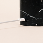 Close-up of the Nero Marquina marble lamp base showing the USB-C charging cable connection
