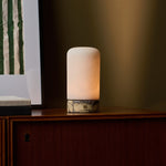 Noé Calacatta Vionaro marbre jaune et albâtre lampe de table rechargeable Tavellio – allumée sur un buffet en bois – lumière dorée