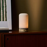 Noé Calacatta Vionaro marbre jaune et albâtre lampe de table rechargeable Tavellio – allumée sur un buffet en bois – lumière dorée