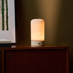 Oplaadbare tafellamp Noé Classic Travertine met albasten kap op houten dressoir in woonkamer
