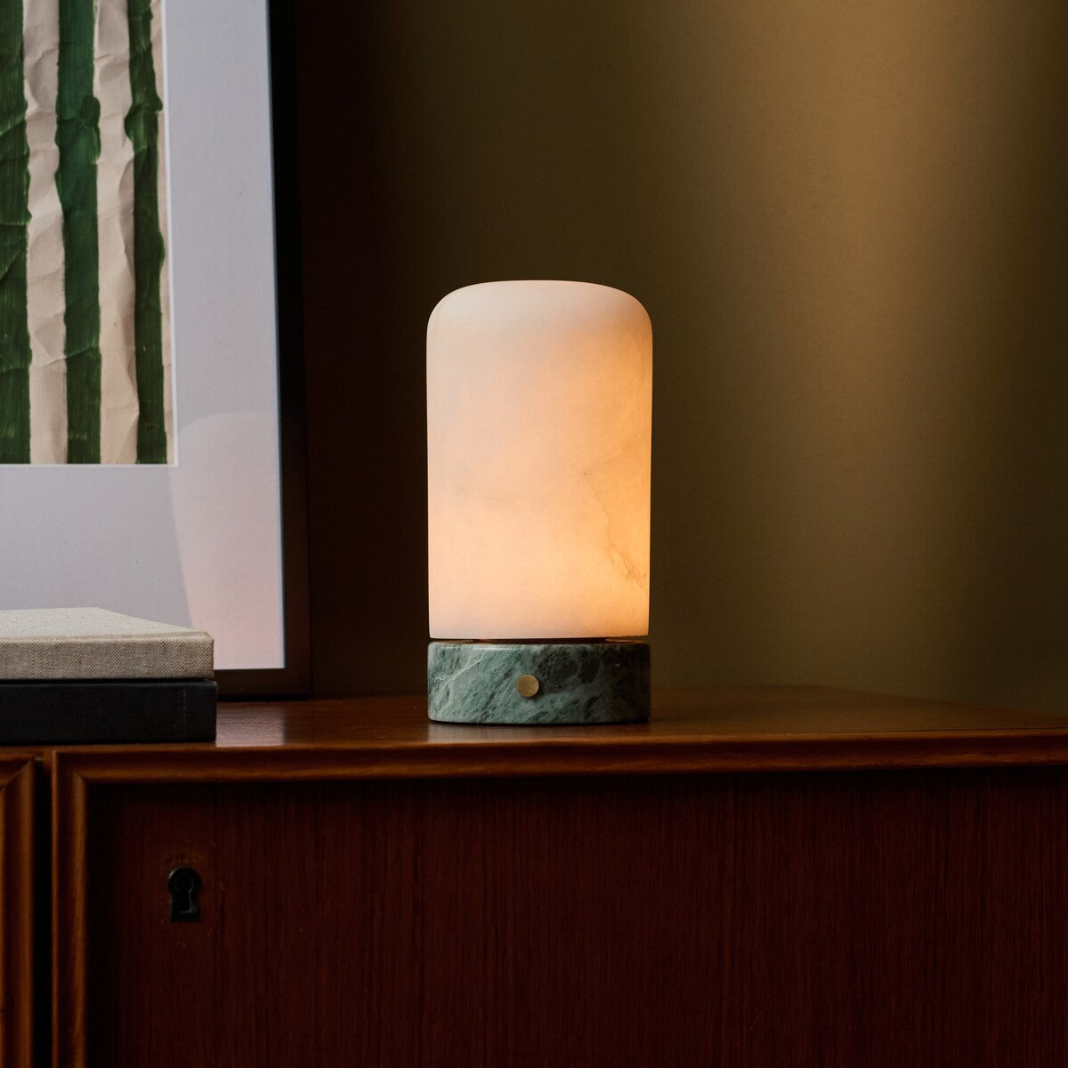 Oplaadbare tafellamp Noé met IJsgroen marmeren voet naast ingelijste print op houten dressoir