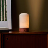 Tafellamp oplaadbaar Noé Red Travertine en alabaster brandend op houten dressoir