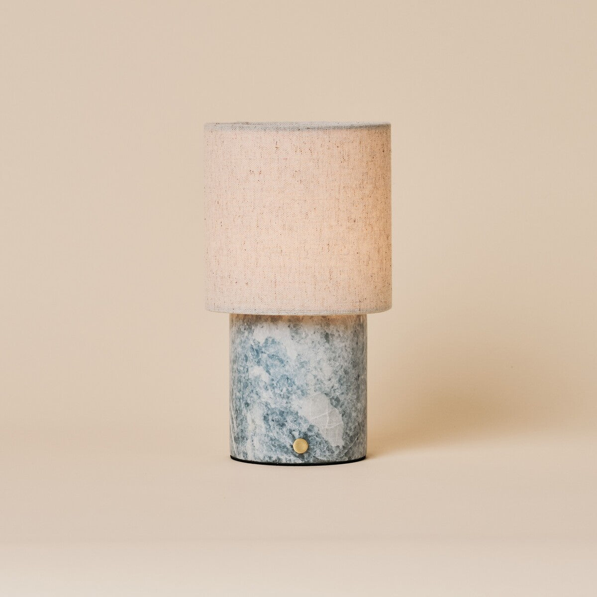 Oplaadbare tafellamp Onoda Medium in Blue Calcite marmer naast houten dressoir