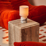 Oplaadbare tafellamp Onoda Medium met witte Calacatta Vionaro marmeren voet op travertine bijzettafel