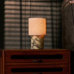 Cordless table lamp Onoda Medium Calacatta Vionaro Yellow marble base lit on a wooden dresser by a window