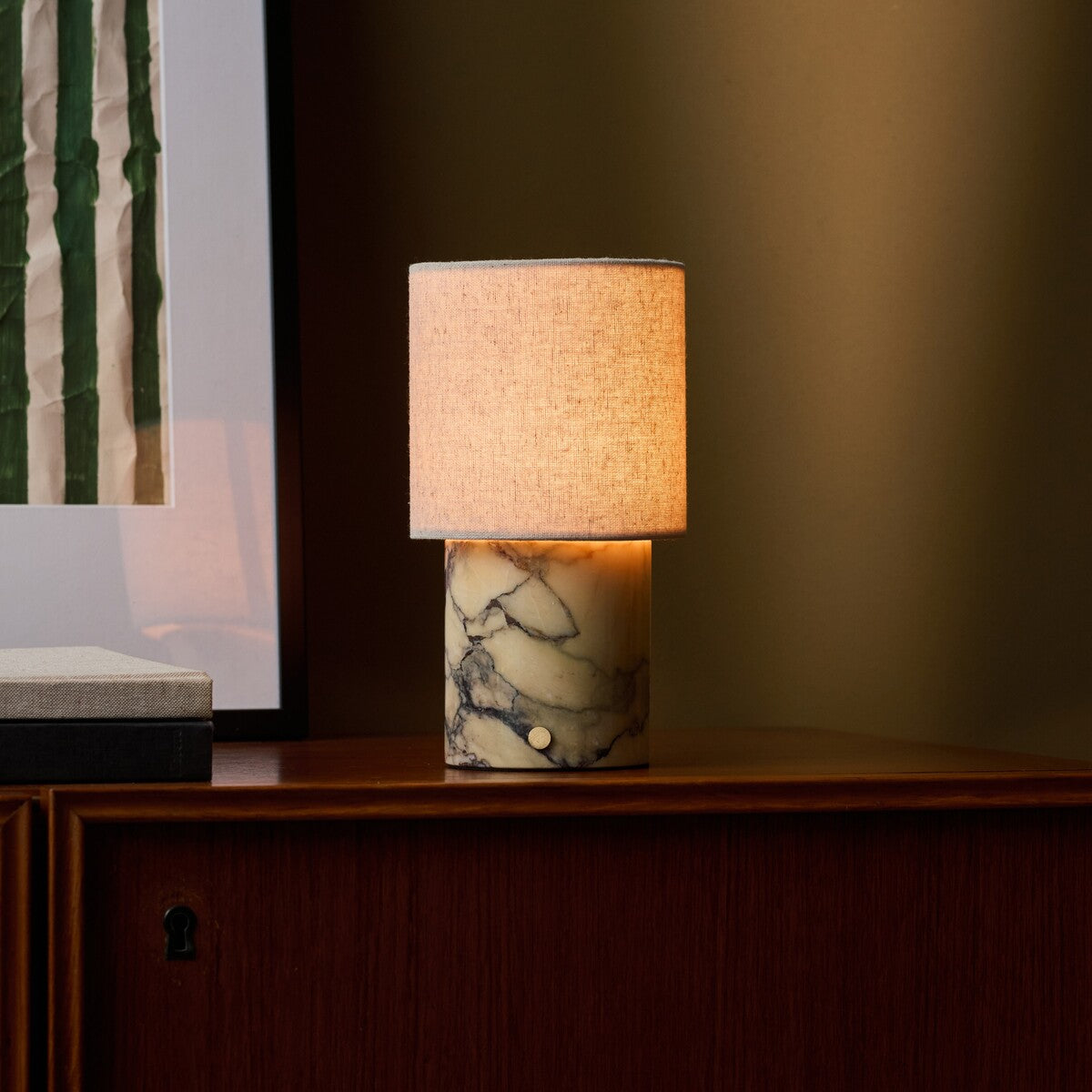 Cordless table lamp Onoda Medium Calacatta Vionaro Yellow marble base on a wooden sideboard at dusk