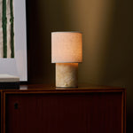 Tafellamp oplaadbaar Onoda Medium Honey Onyx marmeren voet gloeiend op donker houten dressoir