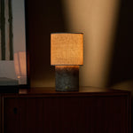 Oplaadbare tafellamp Onoda Medium Silver Travertine marmer op houten dressoir in avondlicht