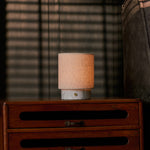 Oplaadbare tafellamp Onoda Small in wit marmer op een vintage houten ladekast