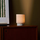 Oplaadbare tafellamp Onoda Small in Bianco Statuarietto wit marmer op een houten dressoir