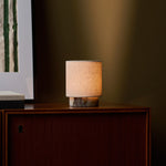 Oplaadbare tafellamp Onoda Small met paars Calacatta Viola marmeren voet op donkere houten kast