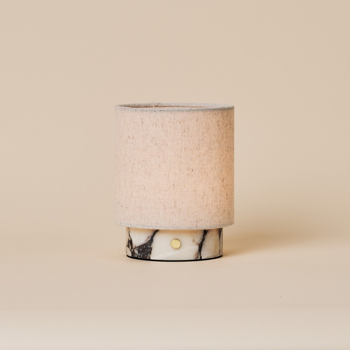 Oplaadbare tafellamp Onoda Small wit Calacatta Vionaro marmeren voet op beige studioachtergrond