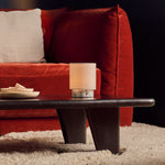 Oplaadbare tafellamp Onoda Small in wit Arabescato marmer op een salontafel bij een rode bank