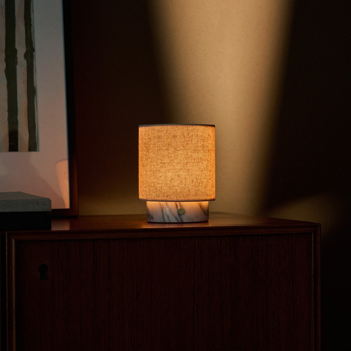 Tafellamp oplaadbaar Onoda Small in wit Arabescato marmer bij een groen schilderij