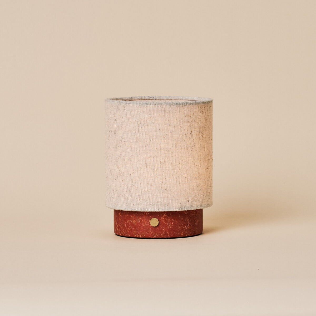 Tafellamp oplaadbaar Onoda Small met rode travertijn voet en linnen kap, studio-opname beige achtergrond