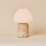 Oplaadbare tafellamp Ostade, beige travertin voet met matglazen kap, studio-opname