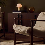 Oplaadbare tafellamp Ostade Medium in Honey Onyx marmer op een stapel boeken in woonkamer setting