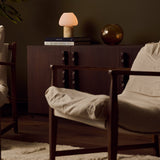 Oplaadbare tafellamp Ostade Medium in Honey Onyx marmer op een stapel boeken in woonkamer setting