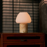 Oplaadbare tafellamp Ostade Medium in Honey Onyx marmer op houten ladekast met jaloezie-schaduw