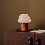 Oplaadbare tafellamp Ostade met Red Travertine marmeren voet en linnen kap op dressoir