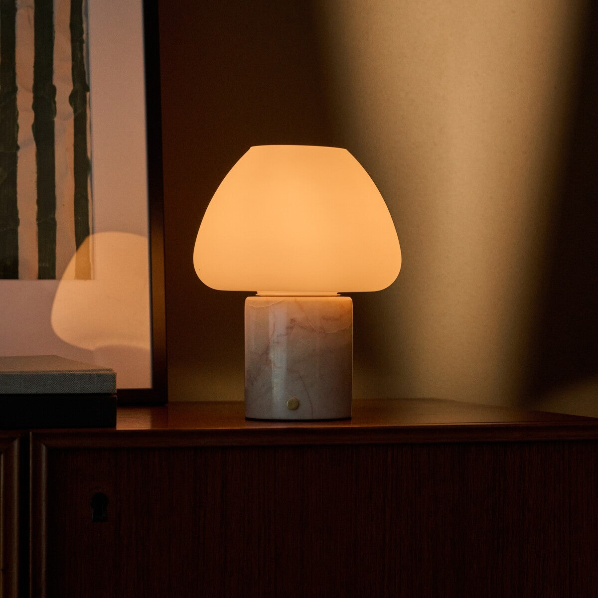 Tafellamp oplaadbaar Ostade Medium in Rosa Aurora marmer op houten dressoir in warm avondlicht