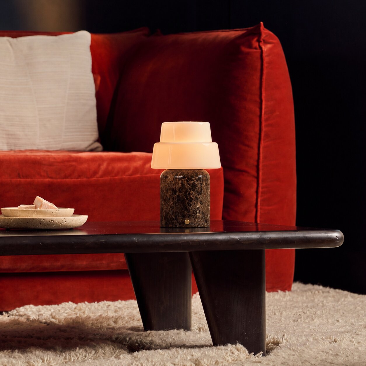 Tafellamp oplaadbaar Pissarro Large Emperador Dark Marble, donkerbruine marmeren voet, op salontafel bij rode bank