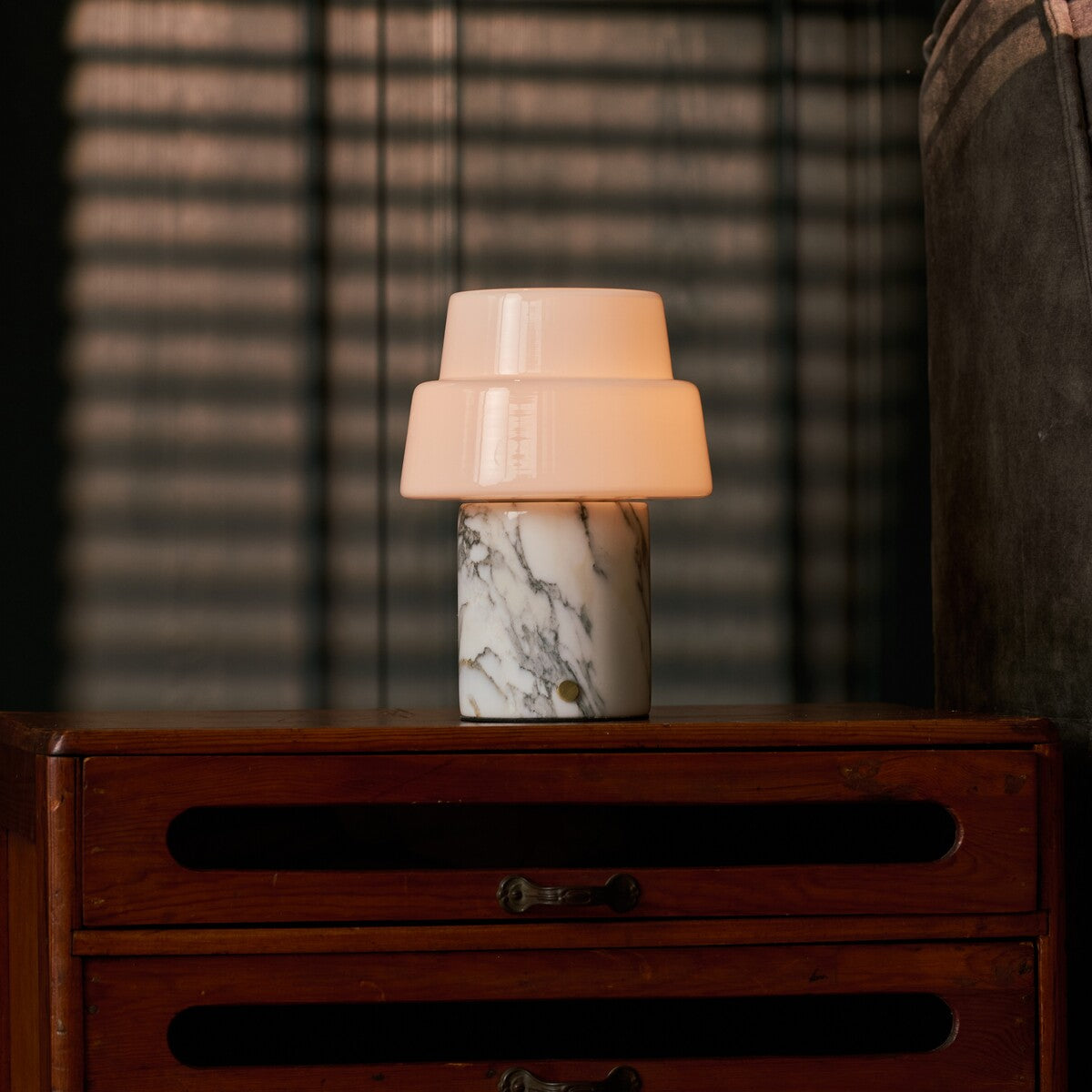 Pissarro rechargeable table lamp with two-tier opal shade and beige marble base on sideboard
