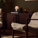 Cordless table lamp with two-tier opal glass shade and red marble base beside bedroom blinds