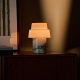 Cordless table lamp with round opal glass globe shade and green marble base in bedroom
