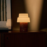 Rechargeable table lamp Pissarro Medium red travertine base with white glass shade, close-up view