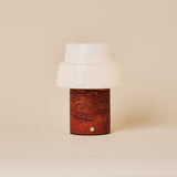 Rechargeable table lamp Pissarro Medium red travertine base with white glass shade on beige backdrop