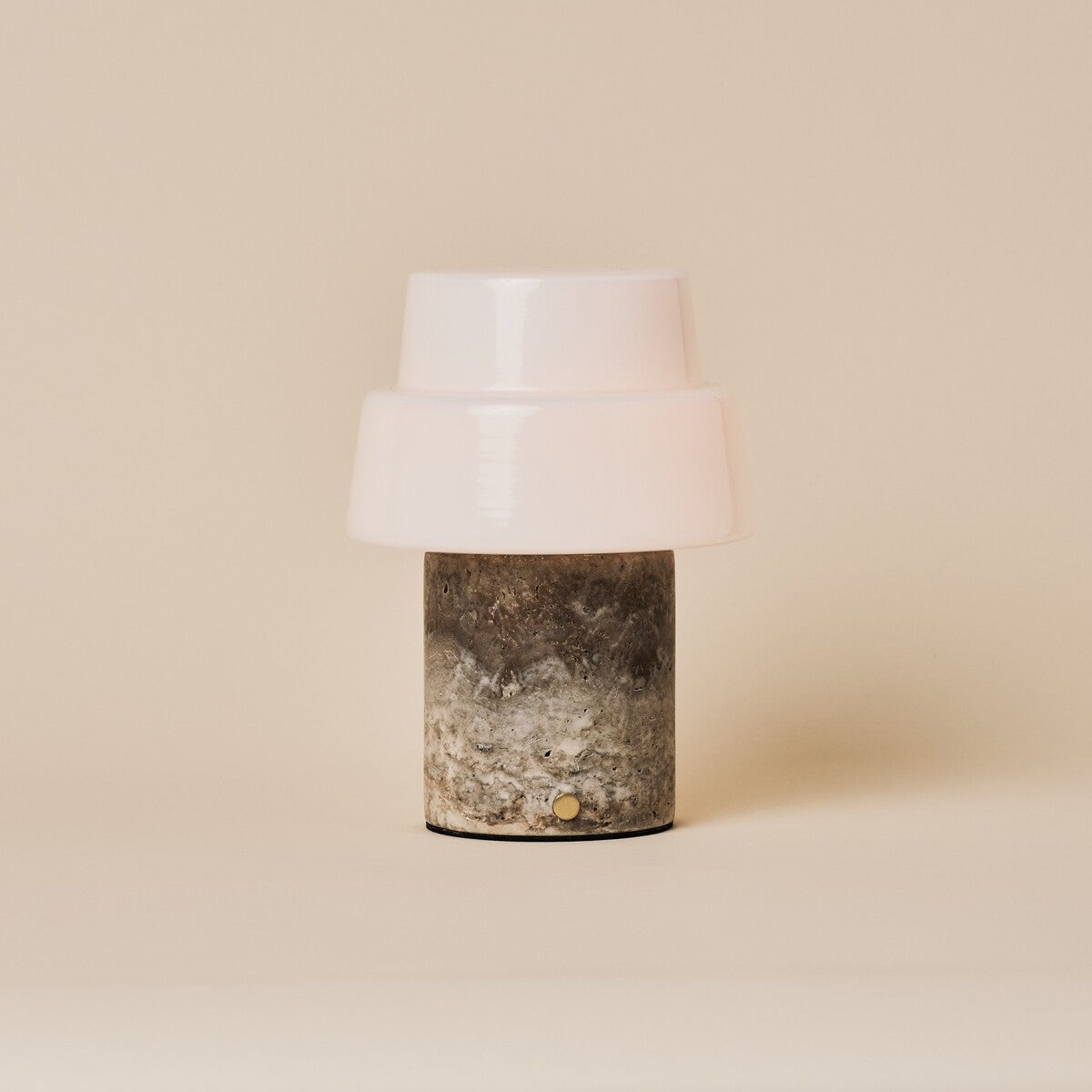 Pissarro cordless table lamp in silver travertine stone shown on a plain studio background