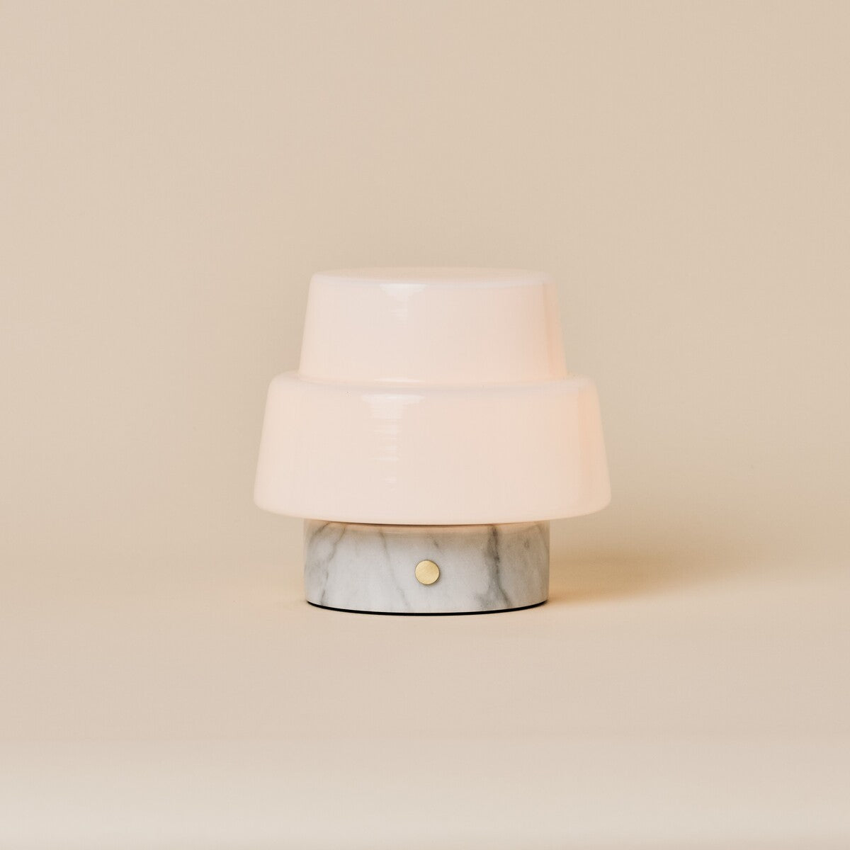 Oplaadbare tafellamp Pissarro Small wit marmer op beige studioachtergrond