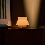 Cordless table lamp Pissarro Small Calacatta Vionaro Pink Marble lit on a dark dresser with framed art