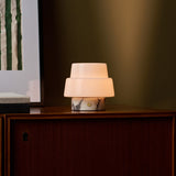 Pissarro Small marbre Calacatta Vionaro lampe de table sans fil Tavellio – posée sur un canapé en velours – abat-jour dôme opalin en verre