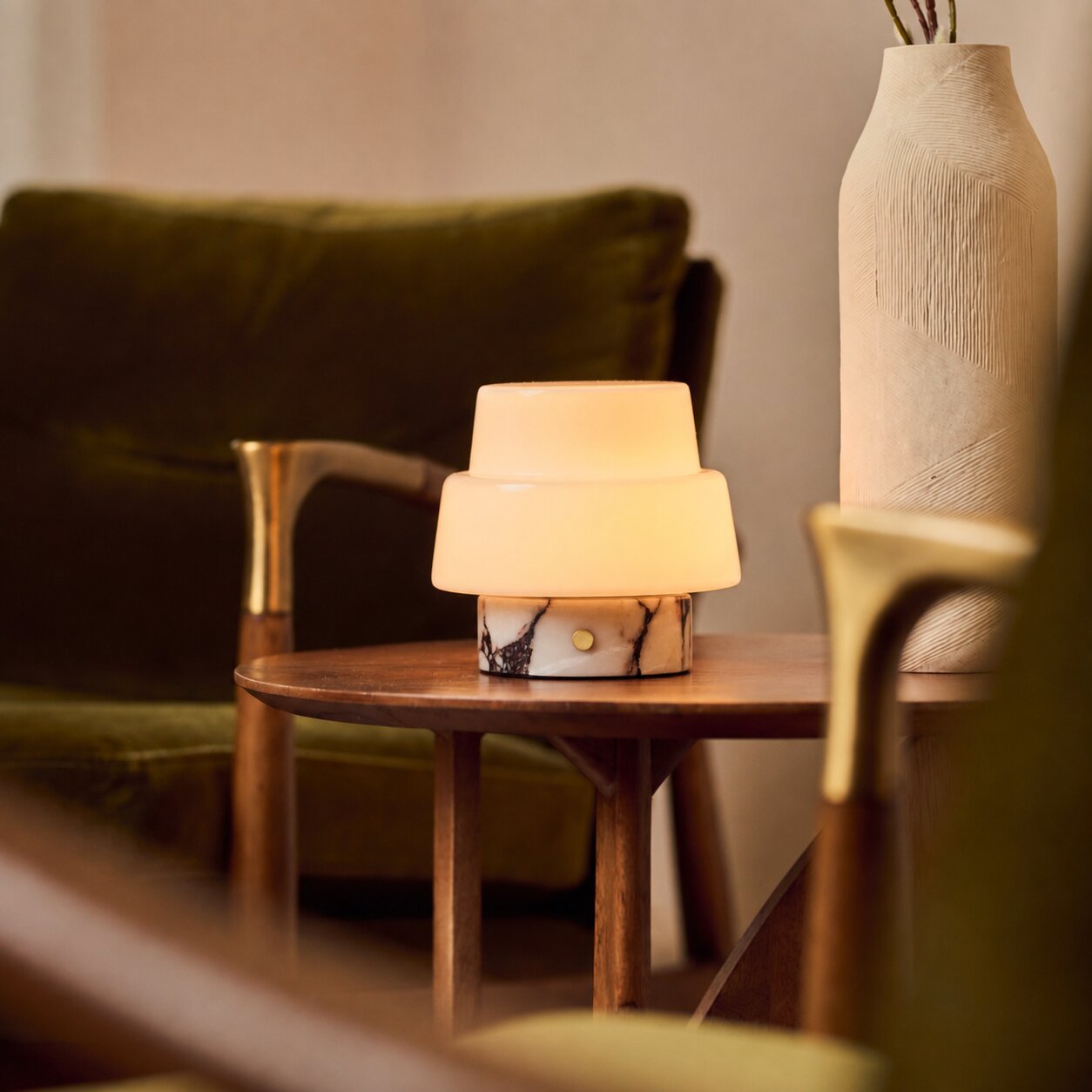 Pissarro Small marbre Calacatta Vionaro lampe de table rechargeable Tavellio – sur un plaid à motifs posé sur un canapé – abat-jour dôme opalin